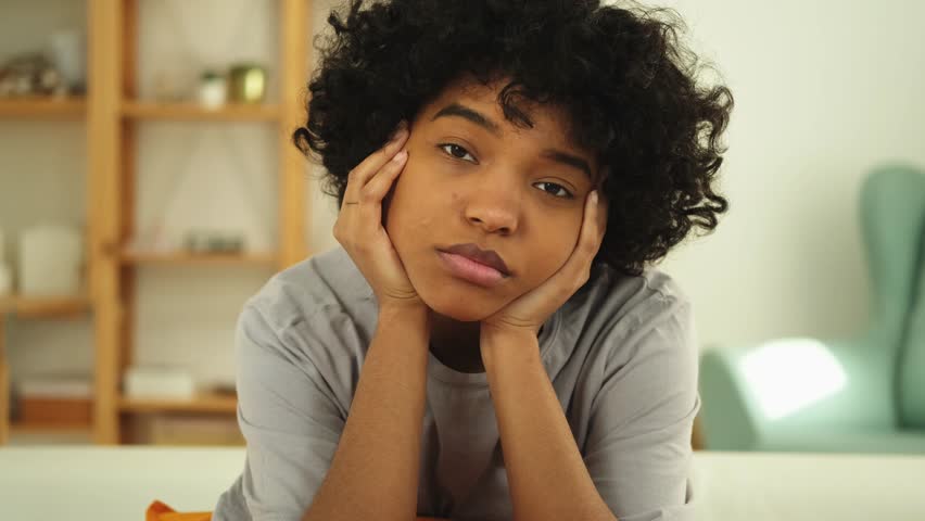African american sad thoughtful girl at home. Young african woman feels depressed offended lonely upset suffers from abuse harassment heartbreak. Grieving violence victim has psychological problem | Shutterstock HD Video #1101848903