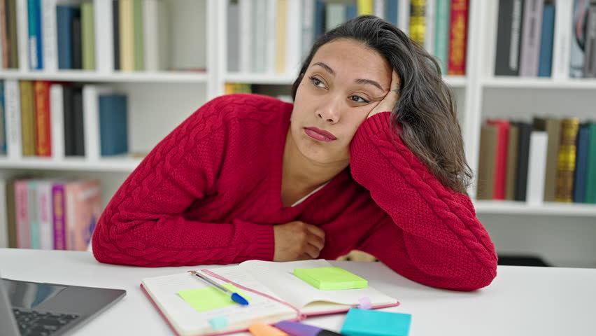 Young beautiful hispanic woman student sleeping on the desk at library university | Shutterstock HD Video #1101850955