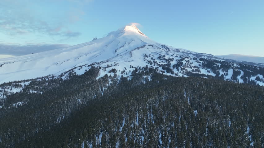 Early morning light shines on Mt Hood, an iconic stratovolcano found about 50 miles southeast of Portland, Oregon. Mt Hood has one of the longest ski seasons in the U.S. due to its annual snow pack.