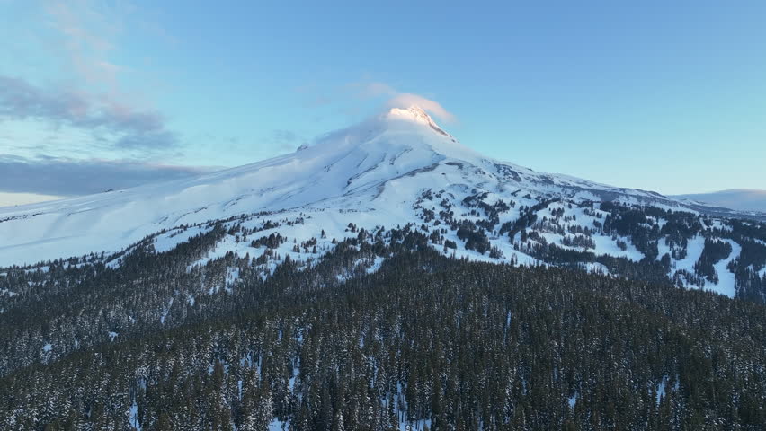 Early morning light shines on Mt Hood, an iconic stratovolcano found about 50 miles southeast of Portland, Oregon. Mt Hood has one of the longest ski seasons in the U.S. due to its annual snow pack.
