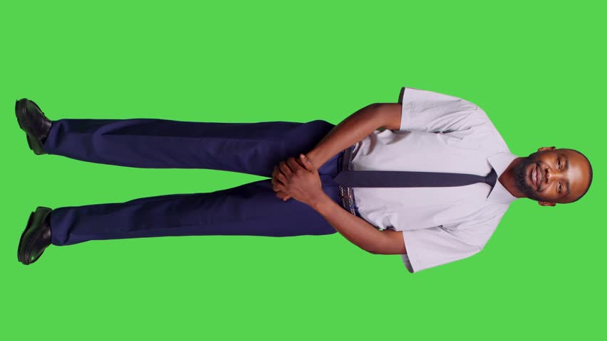 Vertical video: Front view of african american businessman posing in studio over full body greenscreen backdrop, feeling confident wearing formal business suit on camera. Male company employee feeling Royalty-Free Stock Footage #1101853545