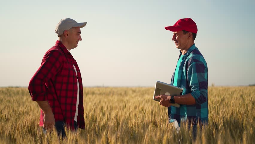 Teamwork in agriculture. Farmers shaking hands in a wheat field at sunset. Rural landscape in countryside. People shaking hands conclusion of a contract. Teamwork in business. Checking wheat harvest. Royalty-Free Stock Footage #1101856813