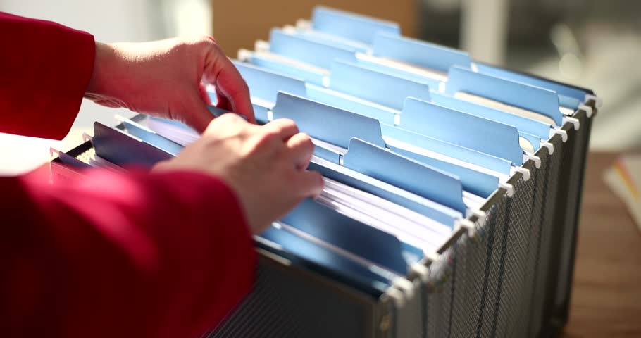 Woman seeks file in card index box in corporate archive Royalty-Free Stock Footage #1101858227