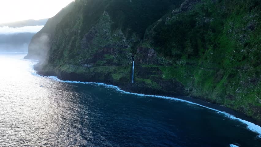 Coastal cliffside waterfall with undulating ocean, Aerial, Madiera, Portugal