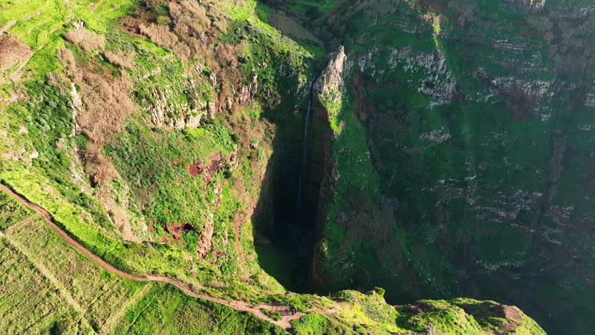 Aerial of long waterfall in green mountainous landscape, Madiera, Portugal
