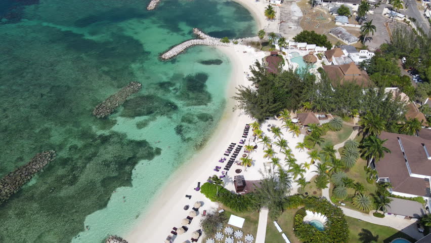 Aerial drone top-down view of sandy beach with turquoise water in Montego Bay, Jamaica, Caribbean sea