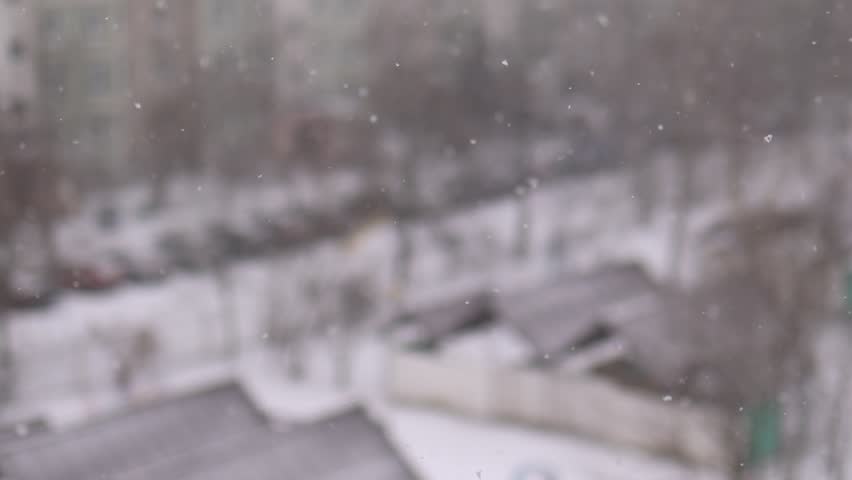 Winter snowfall, Snowstorm in the city, snowflakes fly against the background of houses