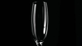 Animation of gold pattern over glass of champagne on black background. celebration and new year's eve party concept digitally generated video.