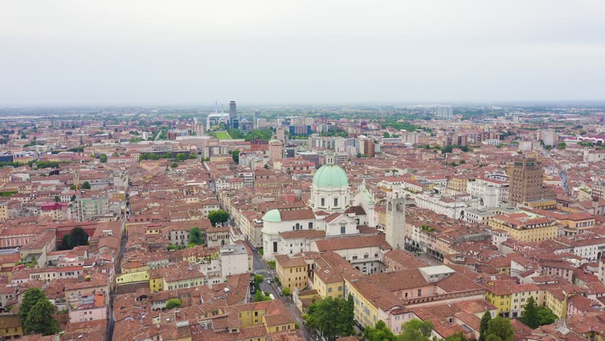 Inscription on video. Brescia, Italy. Cathedral of Santa Maria Assunta. Flight over the city in cloudy weather. Blue lights form luminous. Electric style, Aerial View, Point of interest