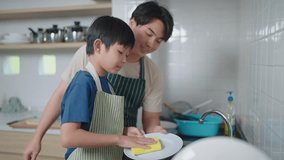 Asian father teaching son to wash dishes in the kitchen at home. Single father concept - Powered by Shutterstock - Get 15% off with code: PIKWIZARD15