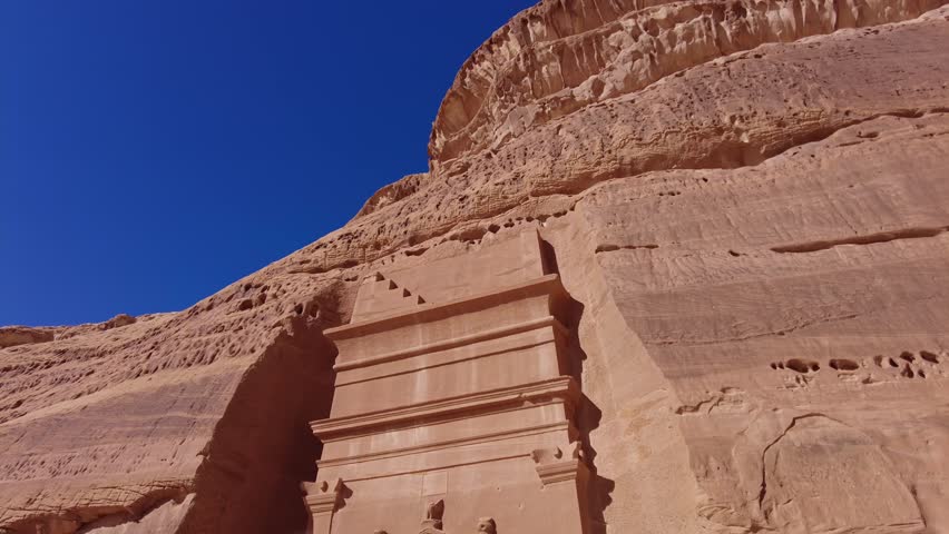 Al Ula - Saudi Arabia: The famous tombs of the Nabatean civilization, Al-Ula being their second largest city after Petra, at the Madain Saleh site in the Saudi desert. Shot with a tilt down motion Royalty-Free Stock Footage #1101881323