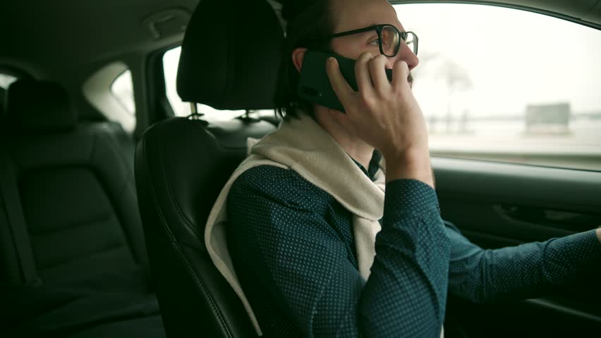 Car Driver Hold Steering Wheel And Talking Phone. Confident Driver Dangerous Driving Car. Joyful Driver Relaxed Turning Steering Wheel Auto Car On Trip. Driver Dangerous Driving SUV Phone Talking Risk | Shutterstock HD Video #1101881417