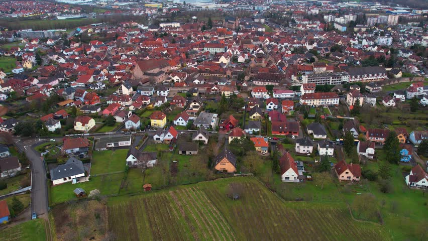 Aerial around the old town of the city Molsheim in France on a cloudy afternoon in later winter. | Shutterstock HD Video #1101883235