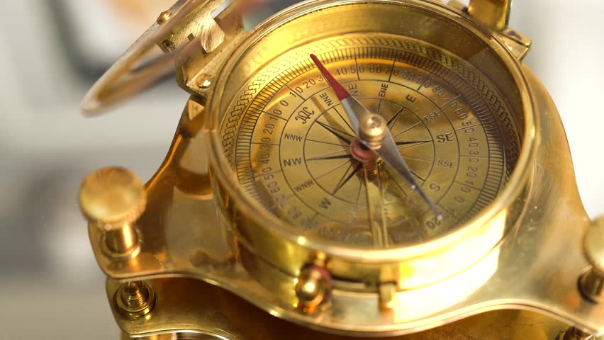 Brass compass on rotating on the mirror. Modern sailor gold brass compass. Macro shot | Shutterstock HD Video #1101883625