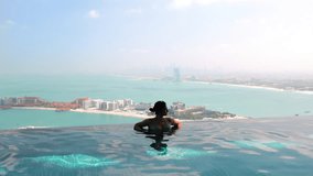 Dubai lifestyle video of travel woman in swimwear enjoying the Dubai skyline view in an infinity pool