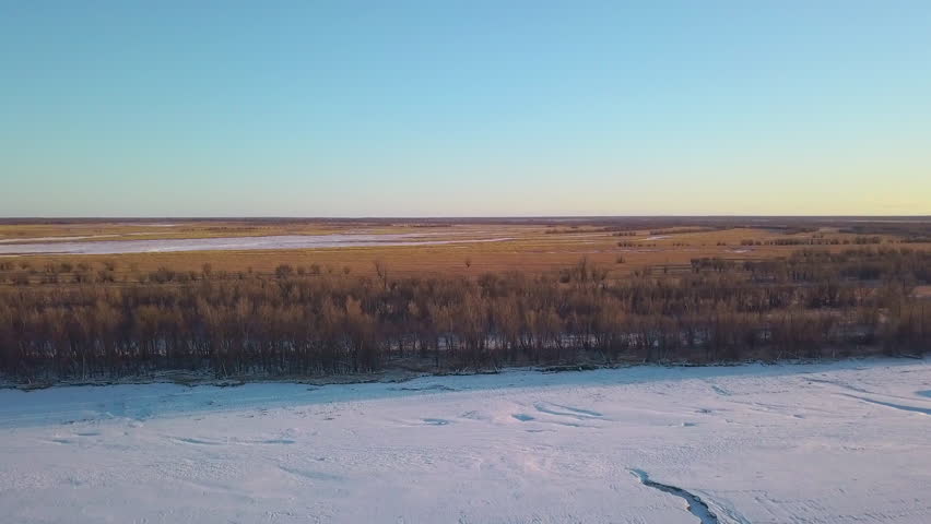 Top view of spring landscape of plains with snow. Clip. Panoramic landscape plain with forest and snow with horizon on sunny day. Forests, meadows and plains with snow on sunny spring day | Shutterstock HD Video #1101885213