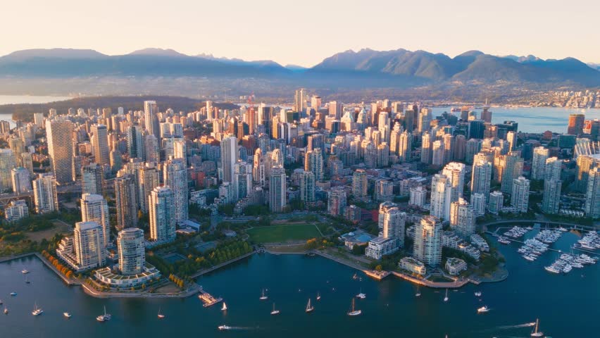 Vancouver downtown skyline aerial pullback reveal shot, British Columbia, Canada at sunset