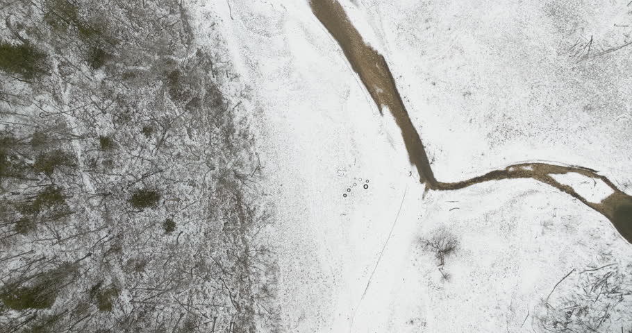 Serene Landscape With Snow-covered Banks By The White River During Winter In Arkansas, USA. aerial topdown
