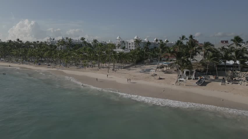 Aerial shot of waves, beach and palm trees on sunny day, Bavaro Beach, Punta Cana, Dominican Republic, West Indies, Caribbean, Central America