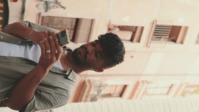 VERTICAL VIDEO: Close-up of young man browsing information on phone