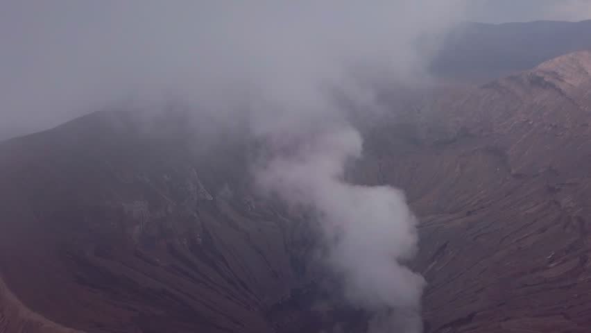Drone aerial view of Volcano Bromo crater edge with steam at Mount Bromo national park in Cemoro Lawang village - East Java, Indonesia, Asia. Travel destinations adventure nature concept
