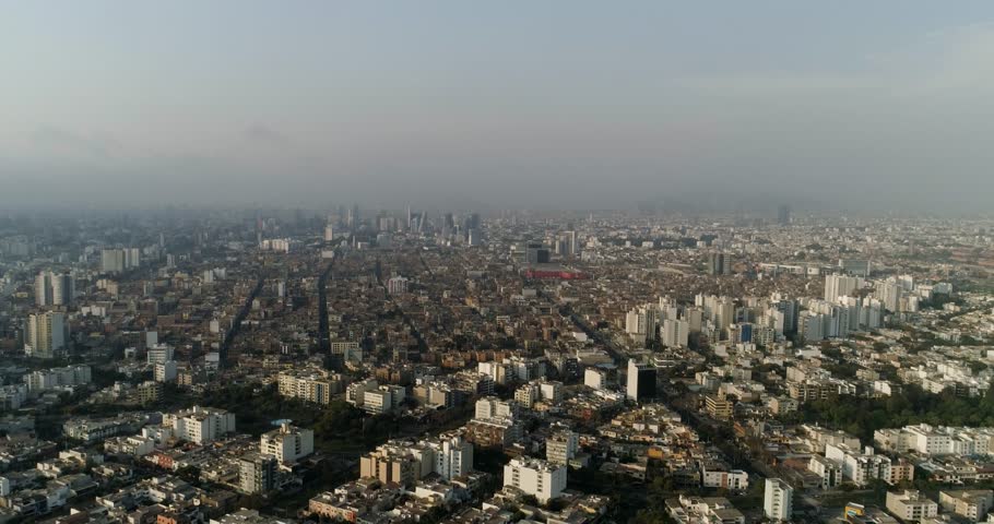 Aerial overview of the metropolis of Lima, hazy sunset in Peru, South America