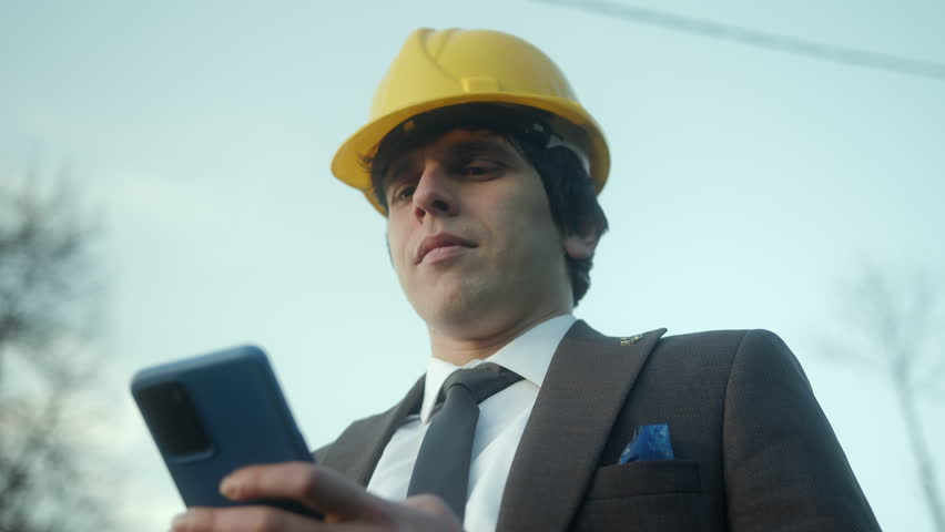 Modern Business and Shopping: A Young Entrepreneur or Civil Engineer Using a Smartphone for Online Purchases | Shutterstock HD Video #1101892321