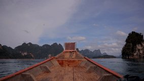 Traditional wooden long tail boat cruise on Cheow Lan Lake among rock formations in Khao Sok National Park, Surat Thani Province in Thailand, Southeast Asia