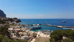 Hyper lapse, Aerial view of exotic resort harbor. Many boats yachts coming and leaving the bay. Anchoring and docking. Colorful houses facades and sailing boats. Time lapse video. Capri Island, Italy.
