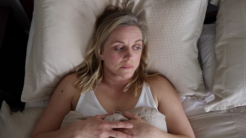 Menopausal Mature Woman Suffering With Insomnia In Bed At Home  Royalty-Free Stock Footage #1101896365