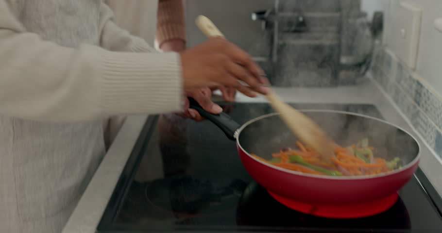 Love, health and black couple cooking food for a healthy vegan diet meal for fresh nutrition in a house kitchen. Smile, African and happy woman prepares organic vegetables for dinner with partner