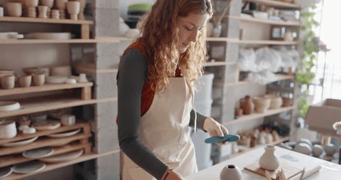 Стоковое видео: Pottery, sculpture and small business owner woman in her startup retail shop or workshop studio for product design process. Young creativity designer entrepreneur artist with clay production career
