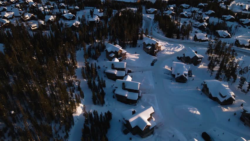 A drone shot of snowy Big Sky, Montana in winter, showcasing the ski resort and majestic mountain terrain.