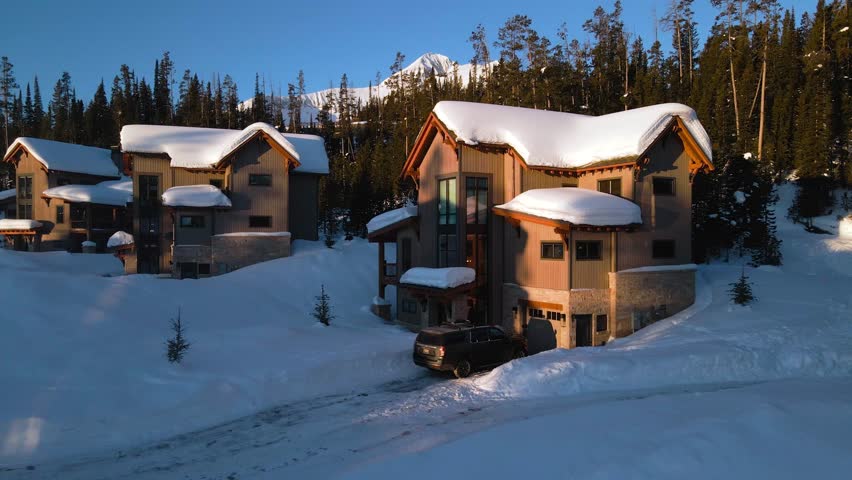 A drone shot of snowy Big Sky, Montana in winter, showcasing the ski resort and majestic mountain terrain.