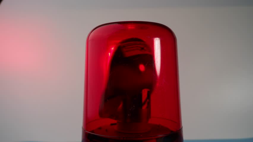 Red rotating beacon. Red flashing light. Warning signal. Close-up.