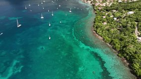 Drone video of the city of Anse d'arlet in Martinique, with its beach, its pier and some boats