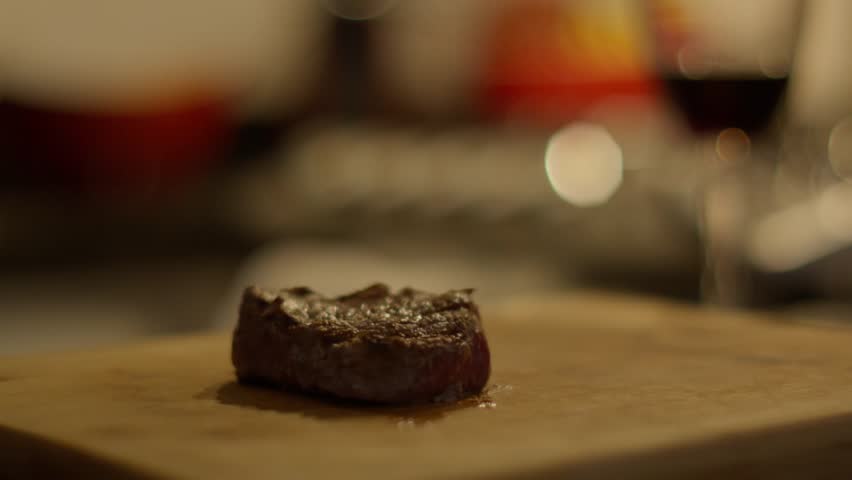cutting meat into pieces on wooden board