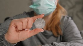 Close-up of a business lady in a medical mask holding a bitcoin coin, an innovative payment network and a new kind of money. Concept of protection against the financial crisis and economic recession. - Powered by Shutterstock - Get 15% off with code: PIKWIZARD15