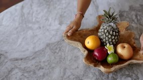 put fruits in a wooden basket on the table