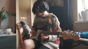teenage girl plays electric guitar in her room. happy family music dreams concept. guitarist girl teenager. learning to play electric guitar at home. young female musician playing lifestyle guitar - Powered by Shutterstock - Get 15% off with code: PIKWIZARD15