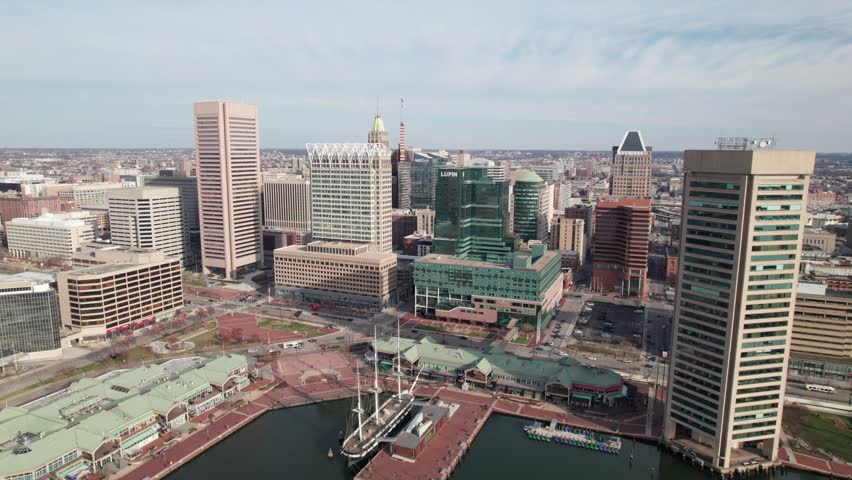Close-up drone shot of downtown Baltimore with historic ships waterfront area in the foreground.
