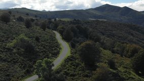 Cyclist pedaling along road of Pyrenees in summer season, France. Aerial drone panoramic view