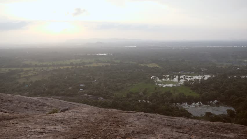 Couple holding hands man leading girlfriend on top of rock at sunset overlooking Sigiriya and green lush tropical jungle in Sri Lanka - Follow me to concept 
