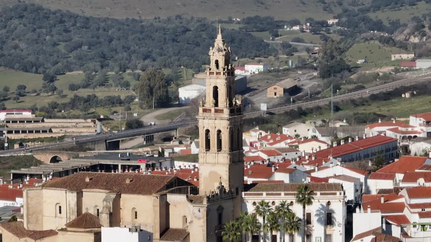Spanish church and town aerial with lush green hills and trees in Parroquia de Santa Catalina. Jerez de Los Caballeros, Badajoz, Extremadura, Spain