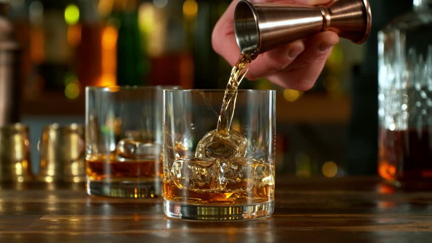 Super slow motion of pouring whiskey or rum with camera motion. Speed ramp effect. Filmed on high speed cinema camera with cinebot, 1000 fps.