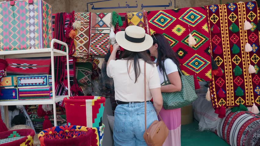 Tourist woman buying at Souq Waqif arab carpet street store in Doha Qatar

