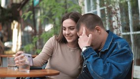 A young couple. Denim clothes. On a date in a vintage restaurant, outside. They are talking. Fooling around. They laugh funny. Taking a selfie with a smartphone. - Powered by Shutterstock - Get 15% off with code: PIKWIZARD15
