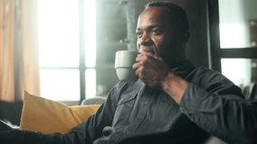 Portrait of handsome mature african american man take sip drinking hot tea or coffee while sitting on couch at home Calm relaxed male enjoying weekend leisure time alone indoors - Powered by Shutterstock - Get 15% off with code: PIKWIZARD15