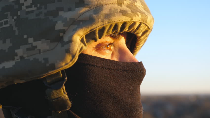 Gaze of male ukrainian army soldier in helmet and balaclava outdoor. Profile view of young military man looking with hope at sunset. Invasion resistance. War between Russia and Ukraine. Close up Royalty-Free Stock Footage #1101948053