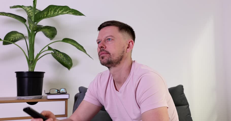 Bearded man gets scared watching horror movie on TV at home